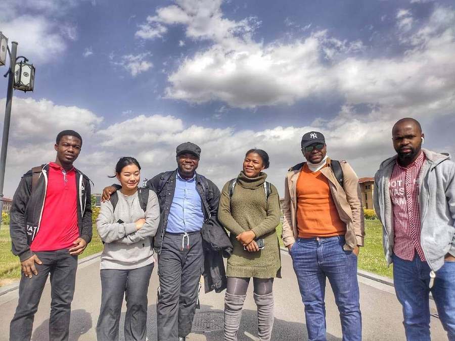 Elvis Kwame Ofori standing outdoors with a group of friends and fellow students during his time in China